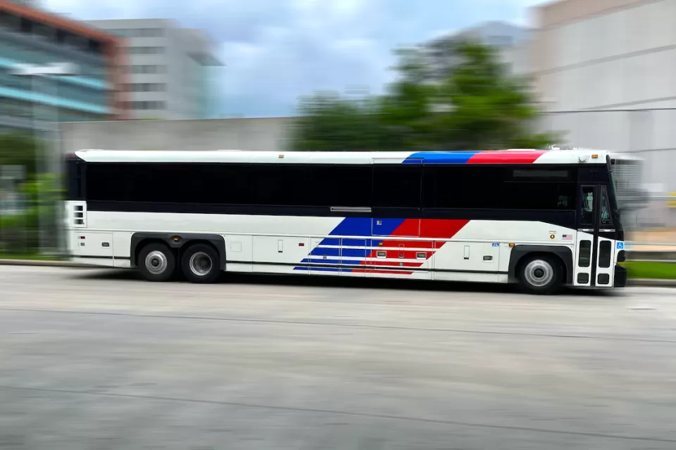 Houston Metro bus moving rapidly across blurred background.